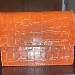 This is a faux leather purse with a crossbody strap